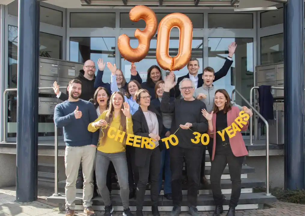 Das Team der Eisenrieth Dokumentations GmbH feiert 30 Jahre Technische Dokumentation vor dem Firmengebäude