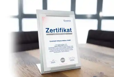 Quanos Silber-Partnerschaft – eDok ist zertifizierter Dienstleister Zertifikat für die Quanos Silber-Partnerschaft der Eisenrieth Dokumentations GmbH auf einem Tisch